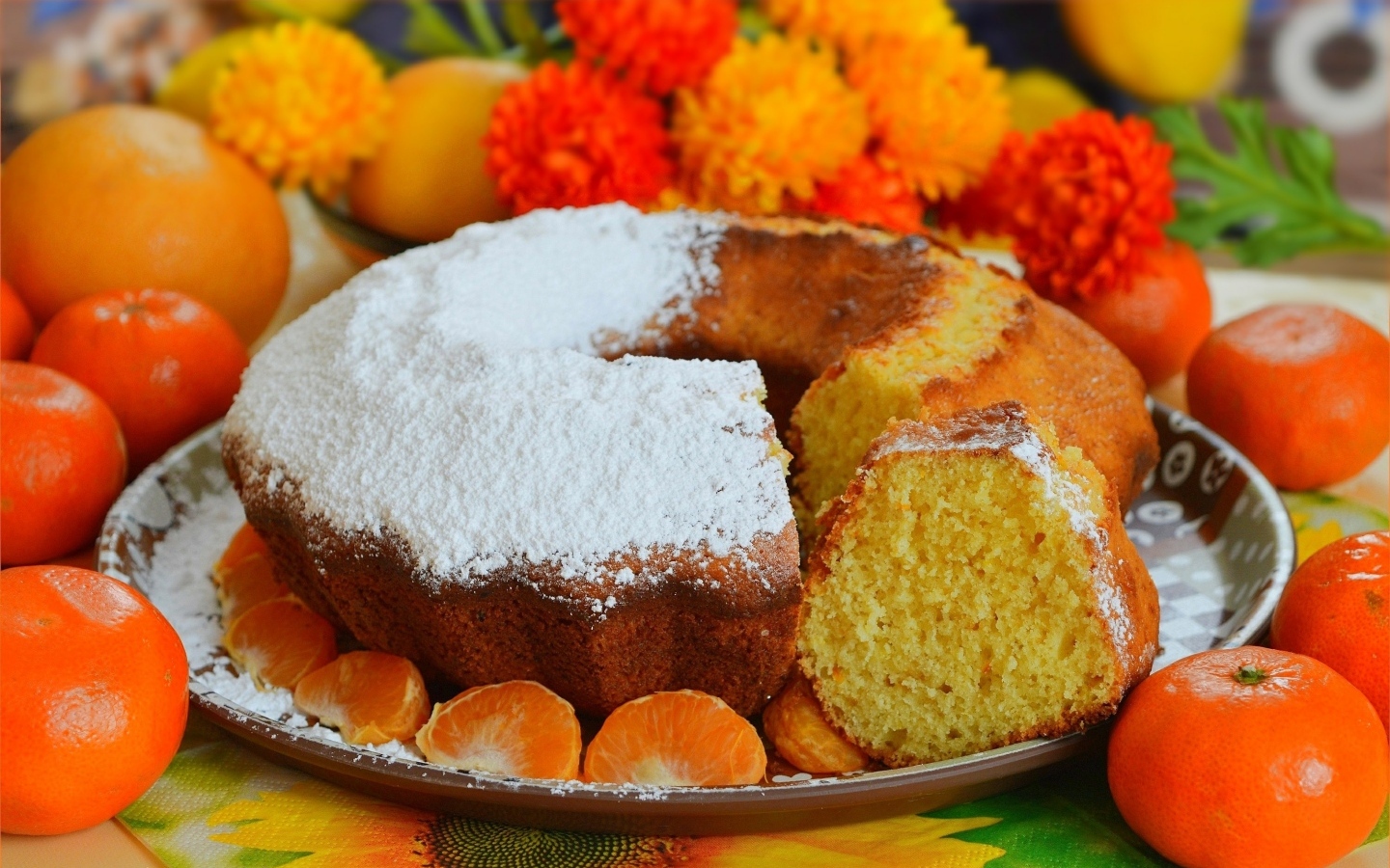 Сладкий пирог на столе с мандаринами и апельсинами