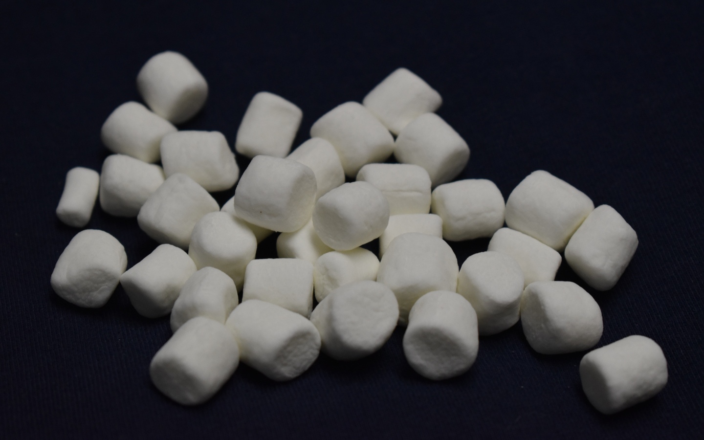 Белое маршмеллоу на черном фоне