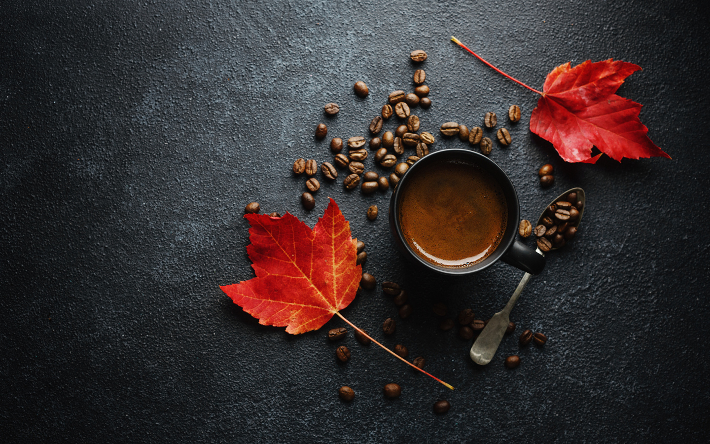Чашка кофе на столе с зернами и желтыми листьями