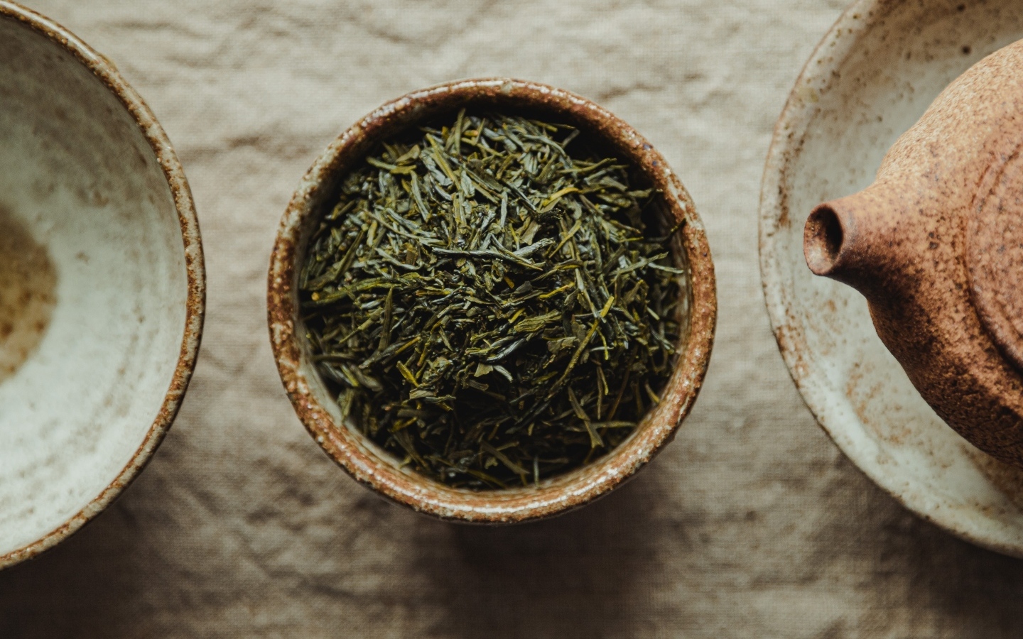 Зеленый чай в пиале на столе с чайником