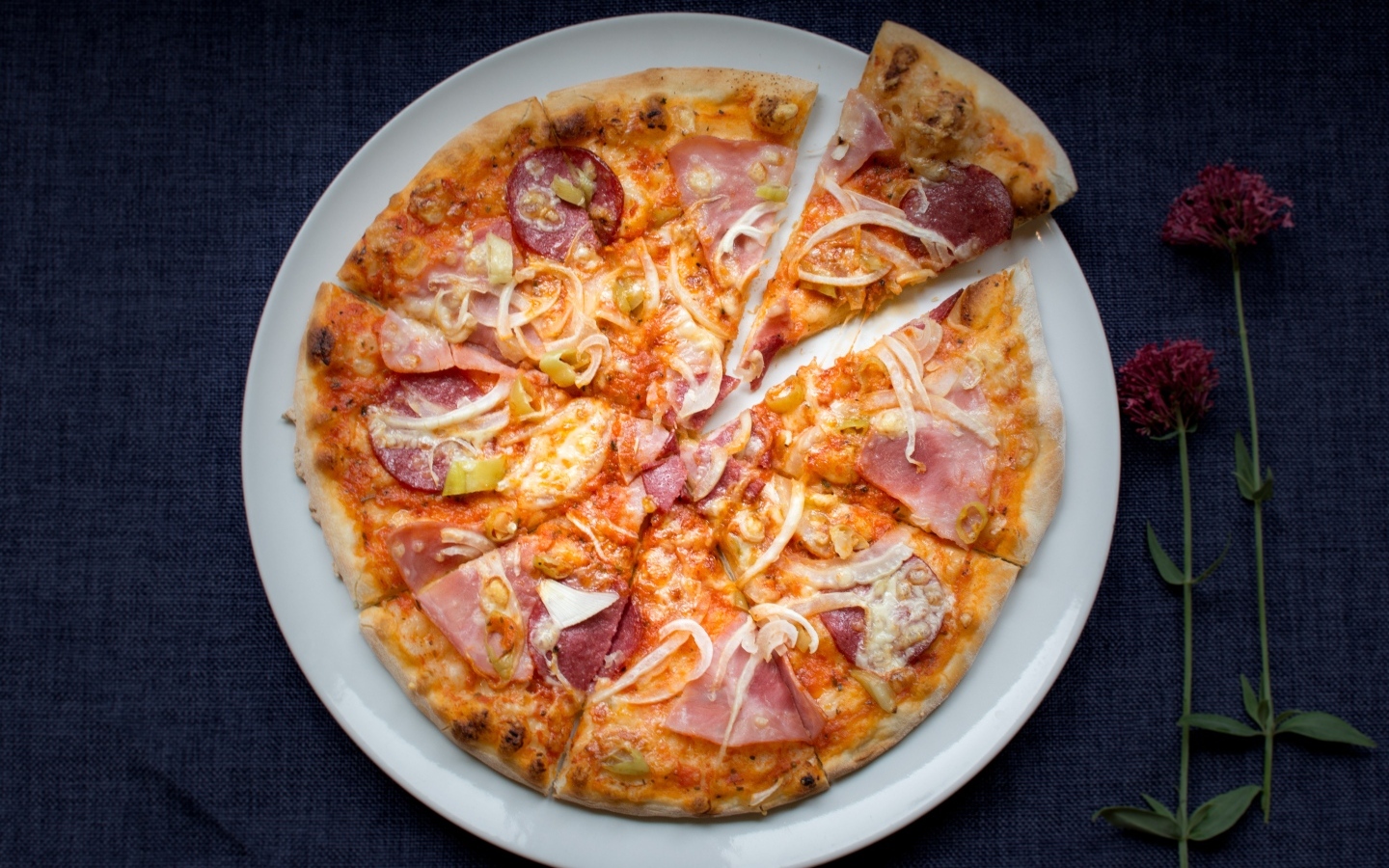 Нарезанная пицца на белой тарелке