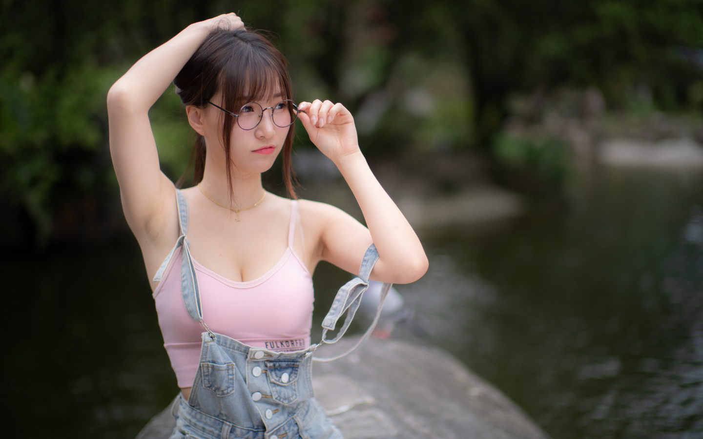 Девушка азиатка в очках и джинсовом комбинезоне