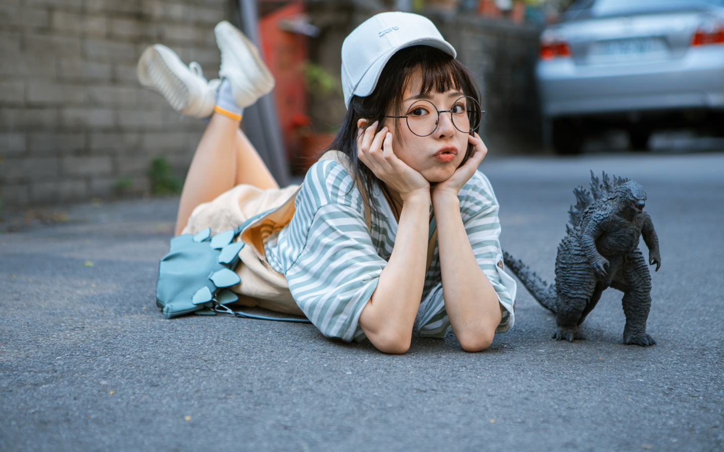 Девушка азиатка с фигуркой годзиллы