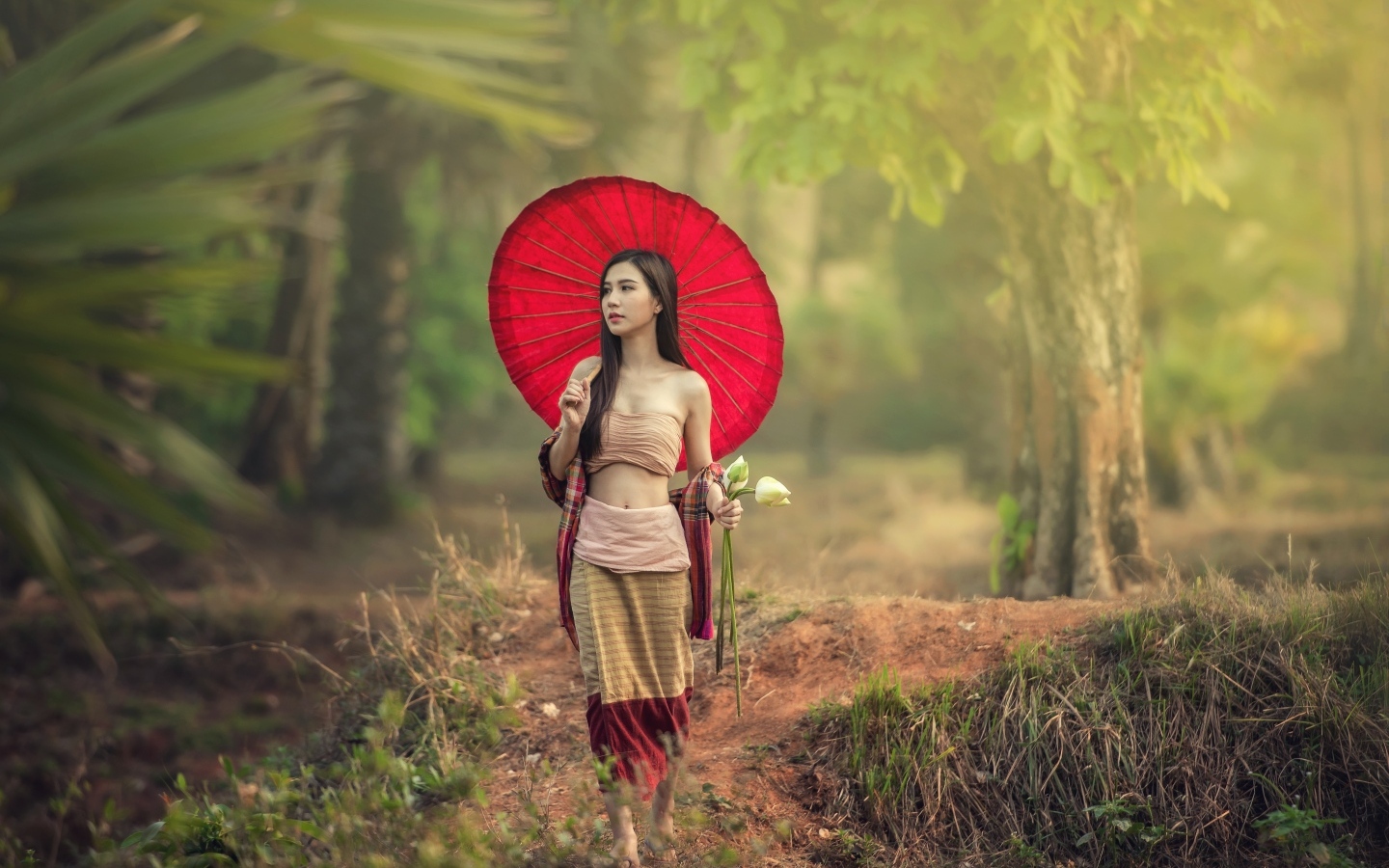 Девушка азиатка с красным зонтом и цветами лотоса