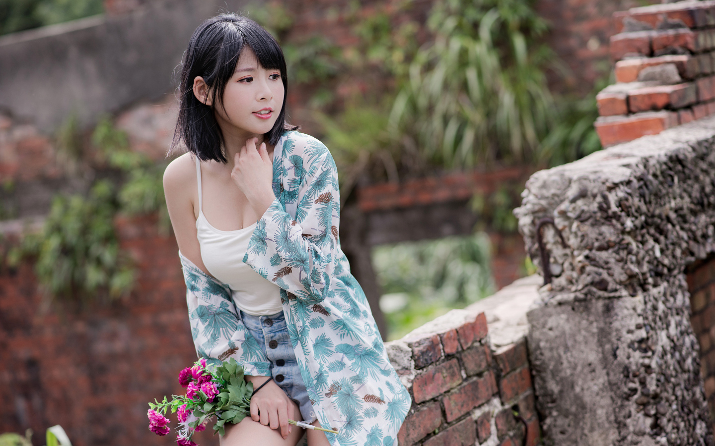 Красивая азиатка с цветком в руке