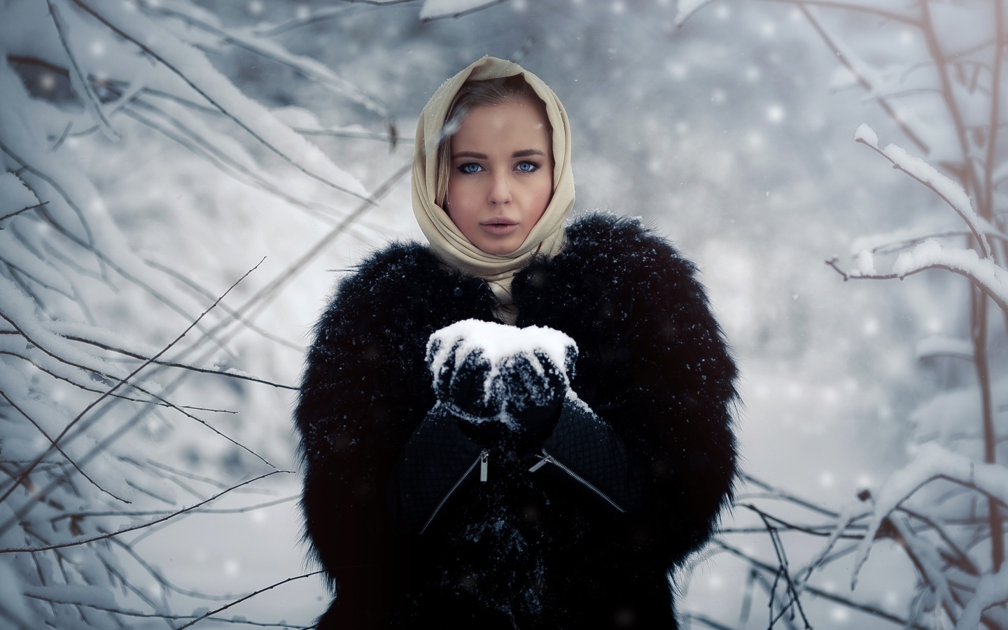 Девушка в черной шубе в заснеженном лесу