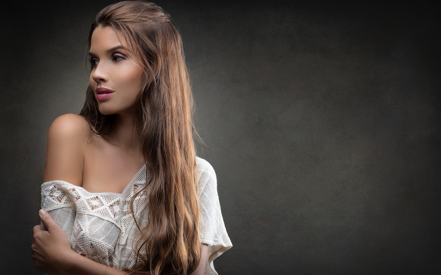 Девушка в белом платье с длинными волосами на сером фоне