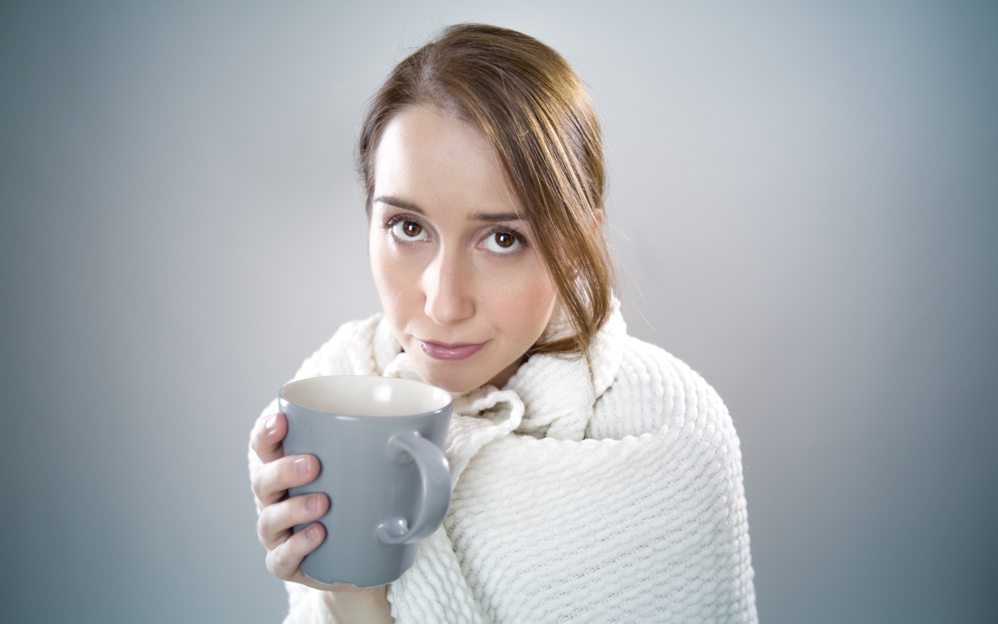 Девушка в белой кофте с кружкой в руке