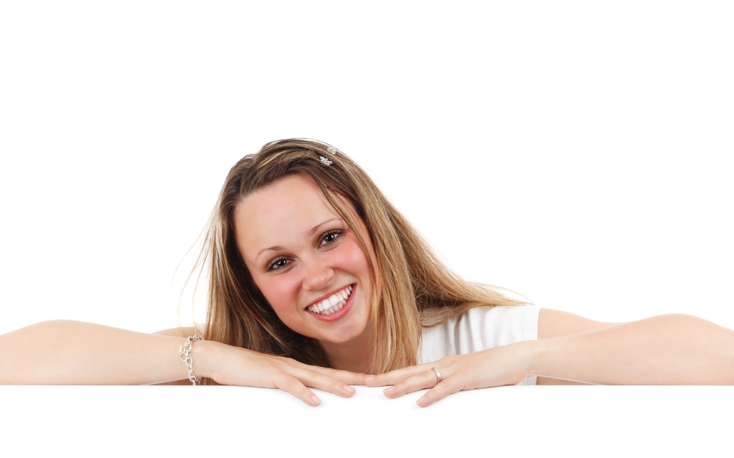 Улыбающаяся девушка сидит на белом фоне