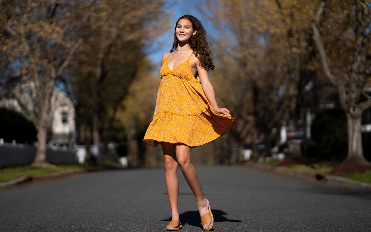 Молодая девушка в коротком платье на дороге  летом