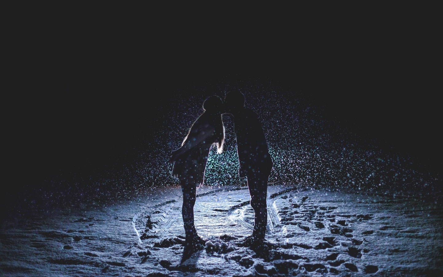 Поцелуй влюбленной пары на снегу ночью