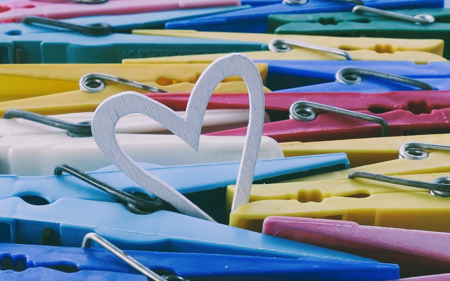 Белое деревянное сердце с разноцветными прищепками