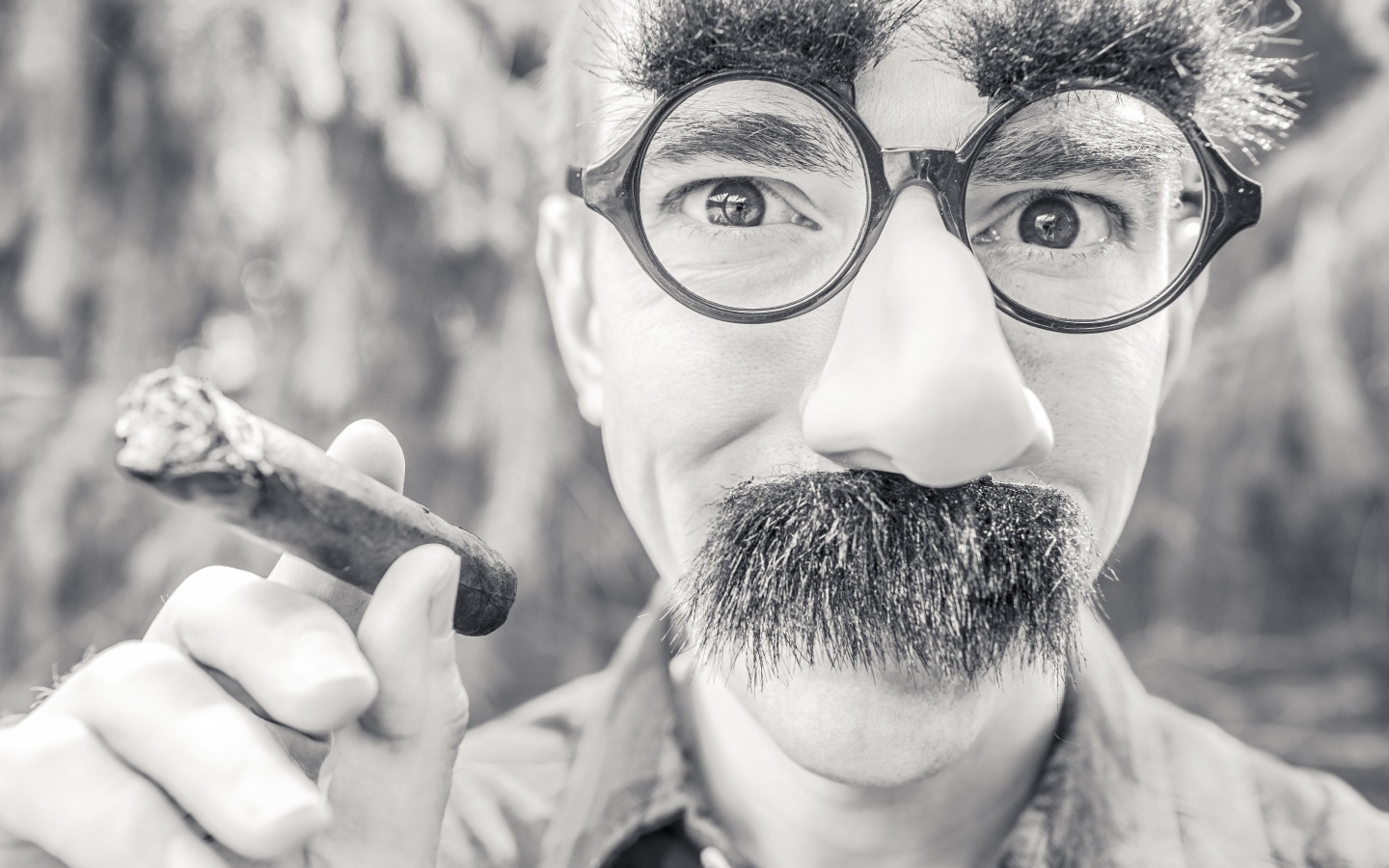 Мужчина в очках с сигарой в руке