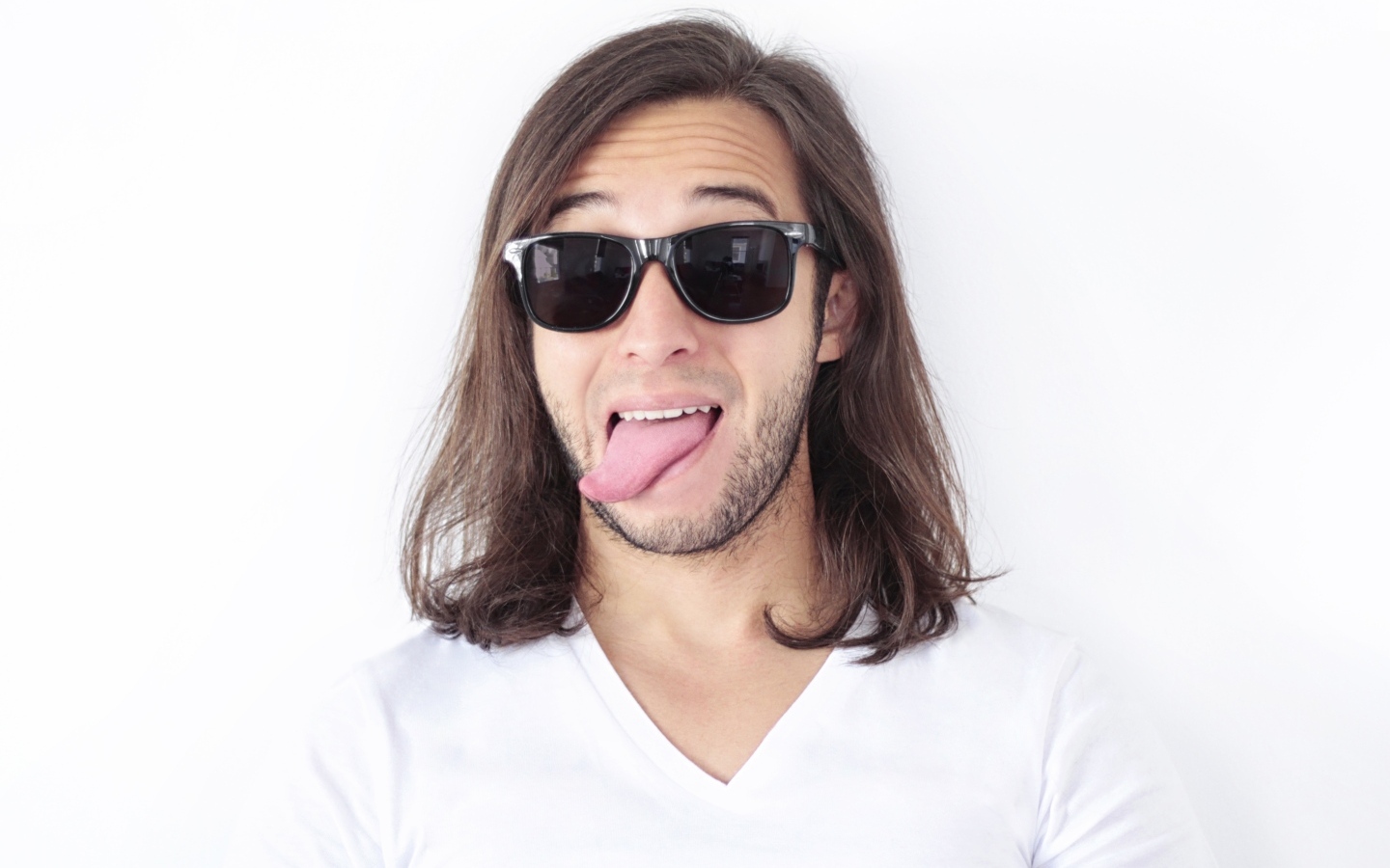 Мужчина в очках с высунутым языком