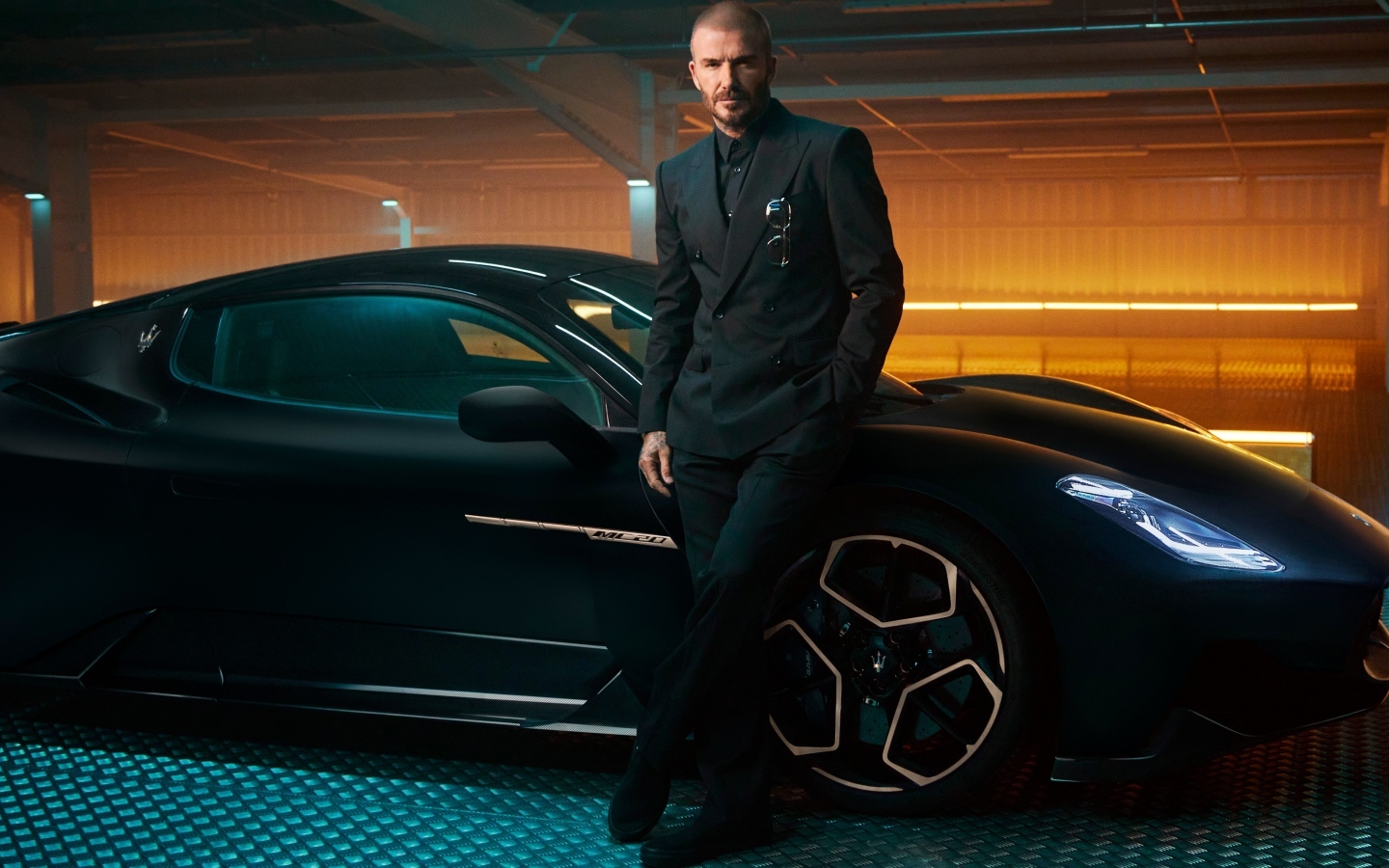Футболист Дэвид Бекхэм у черного автомобиля Maserati MC20