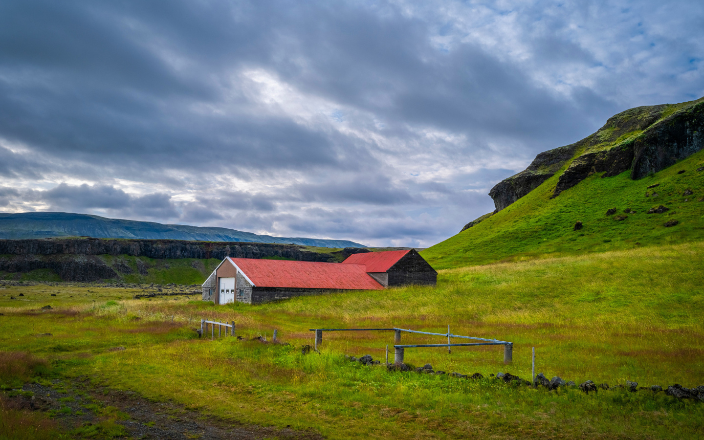 Дом у покрытой зеленью поры под грозовым небом