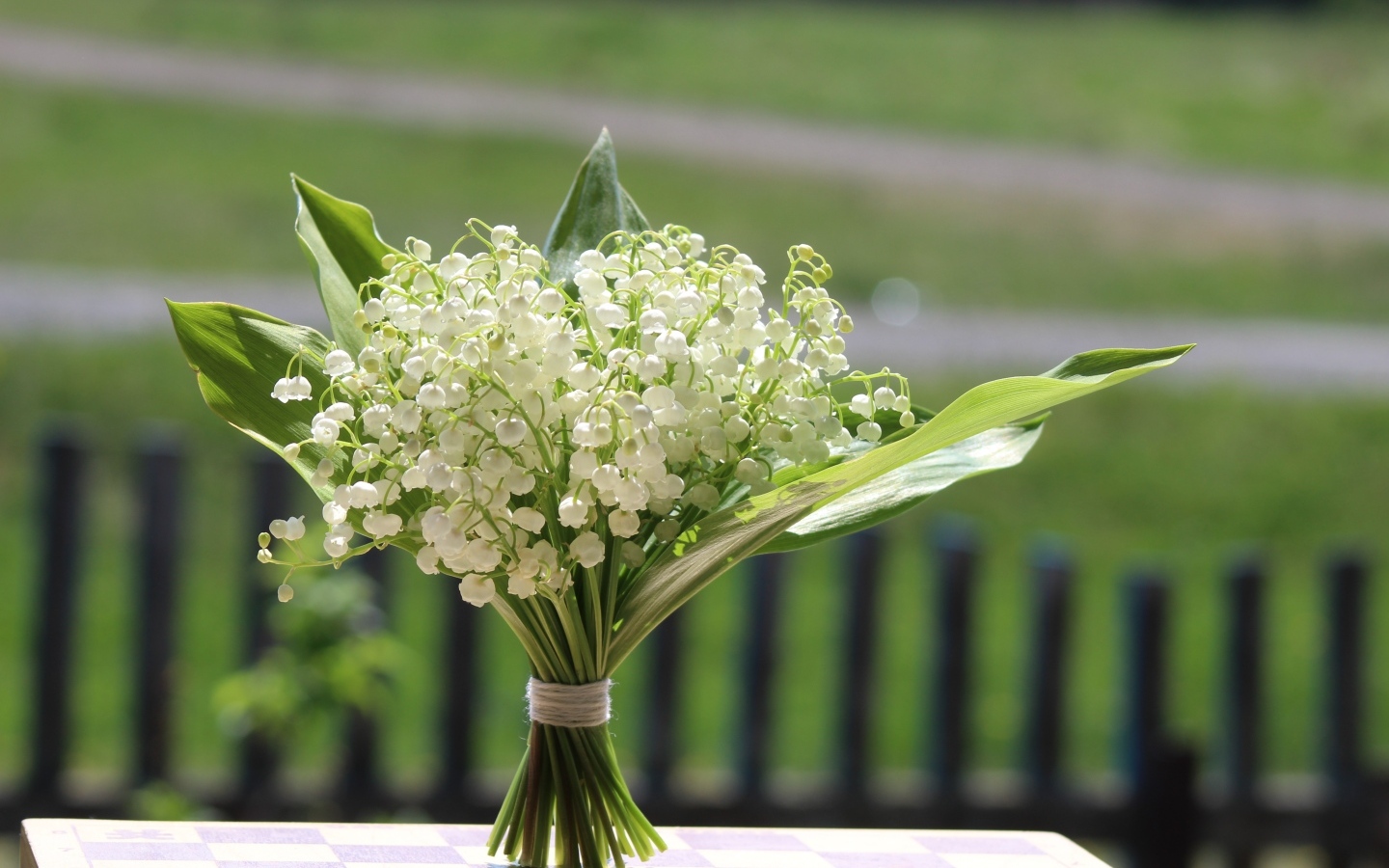 Красивый букет белых ландышей на столе в вазе