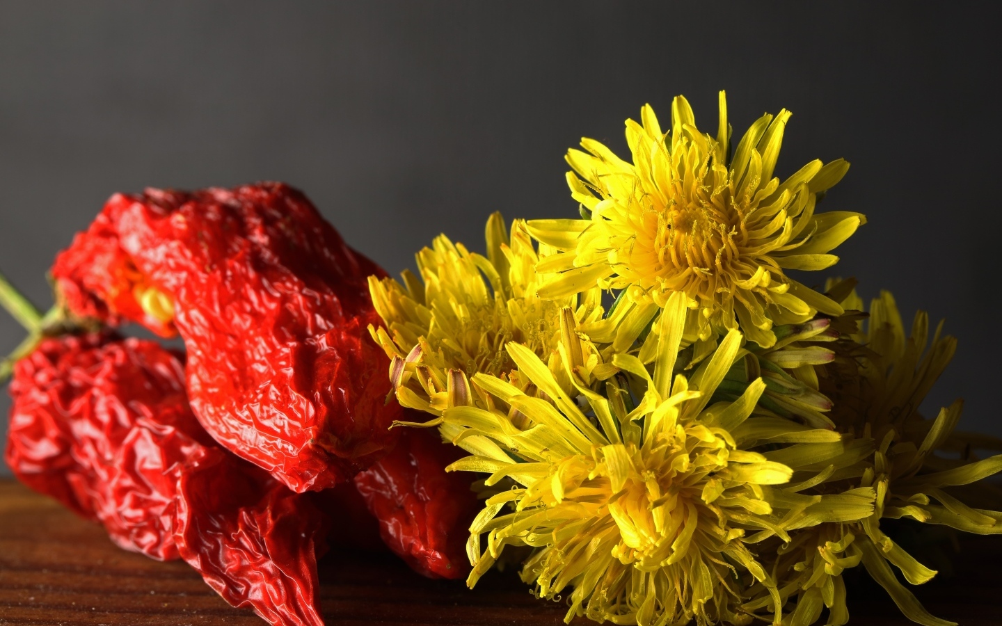 Желтые одуванчики с красным перцем на столе