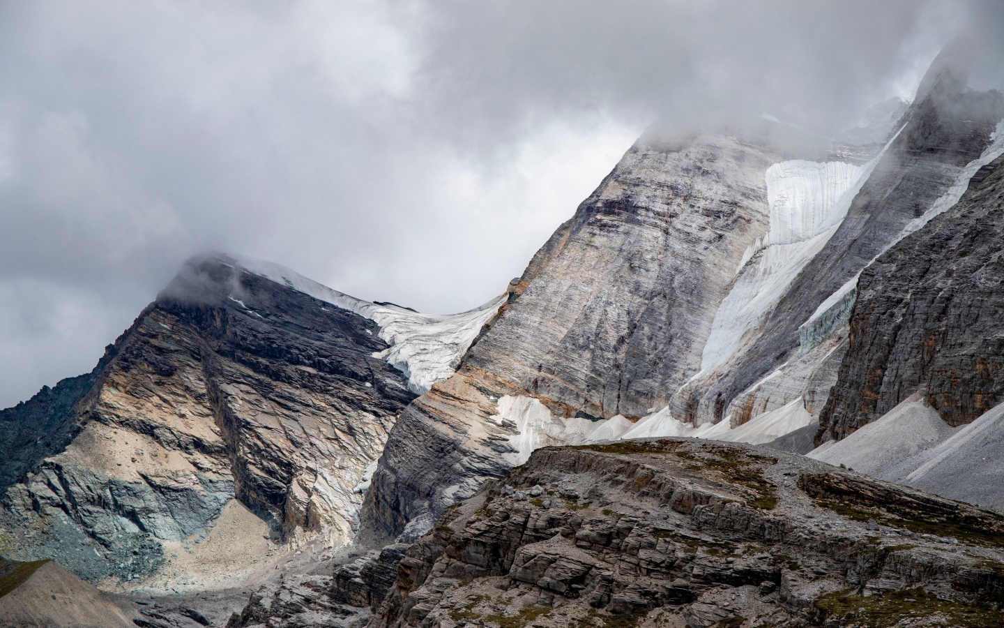Высокие каменные горы в белых облаках