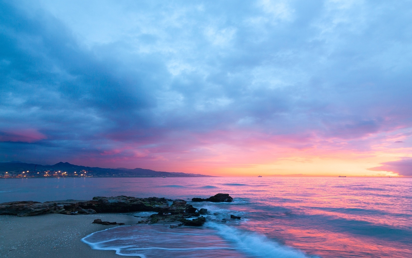 Розовый закат в пасмурном небе над морем