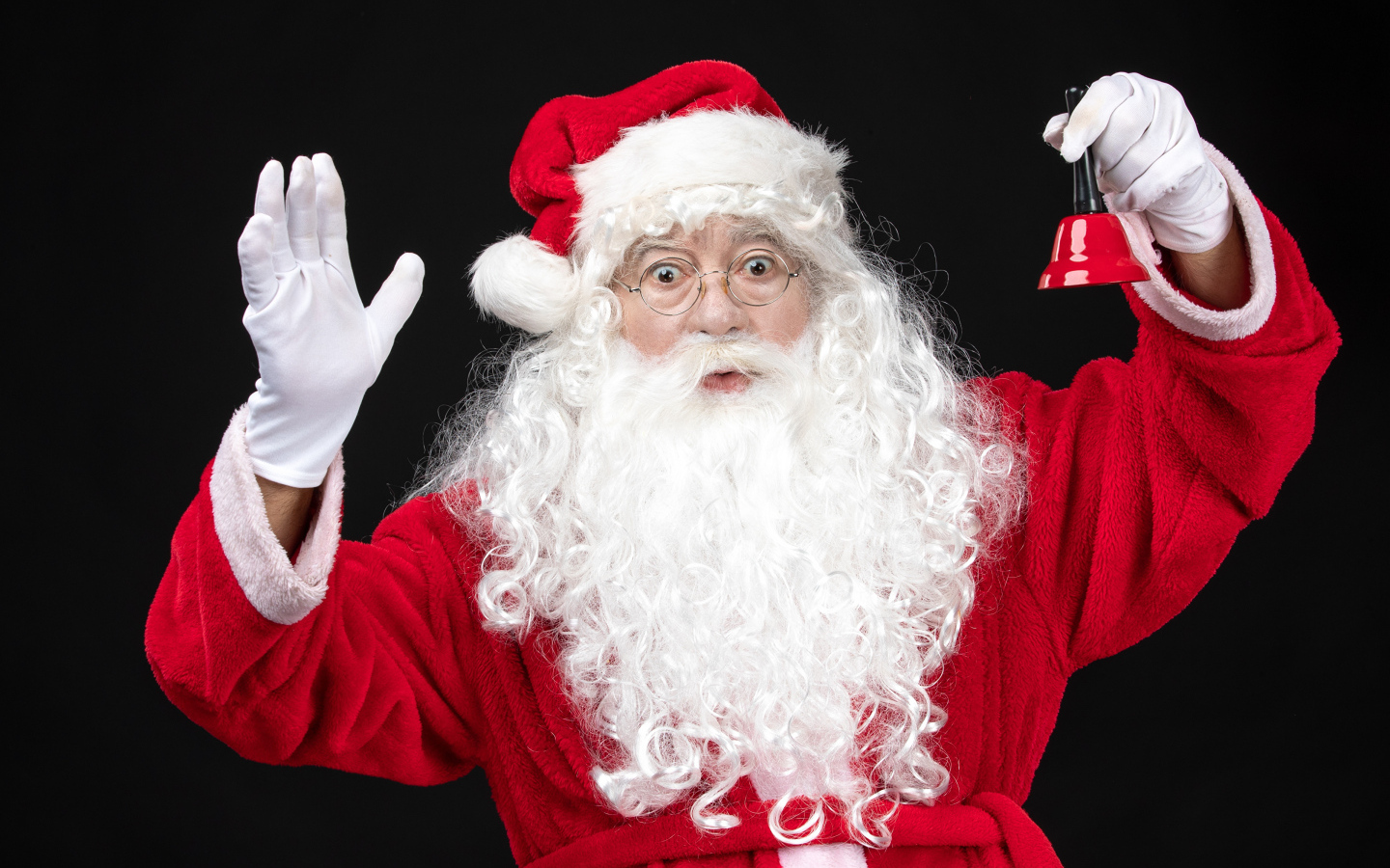 Удивленный Санта Клаус с колокольчиком в руках