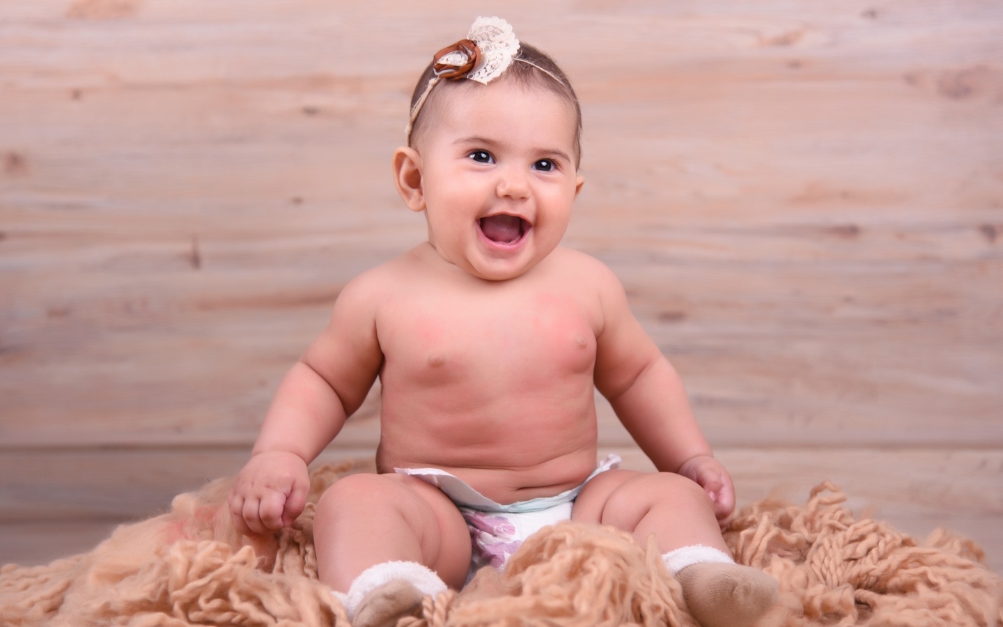 Милый улыбающийся ребенок на фоне деревянной стены