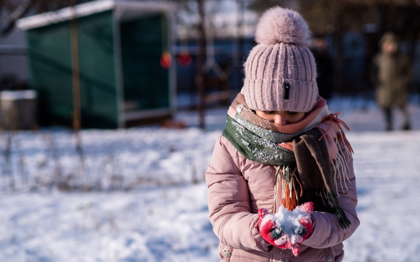 Девочка держит снег в руках зимой