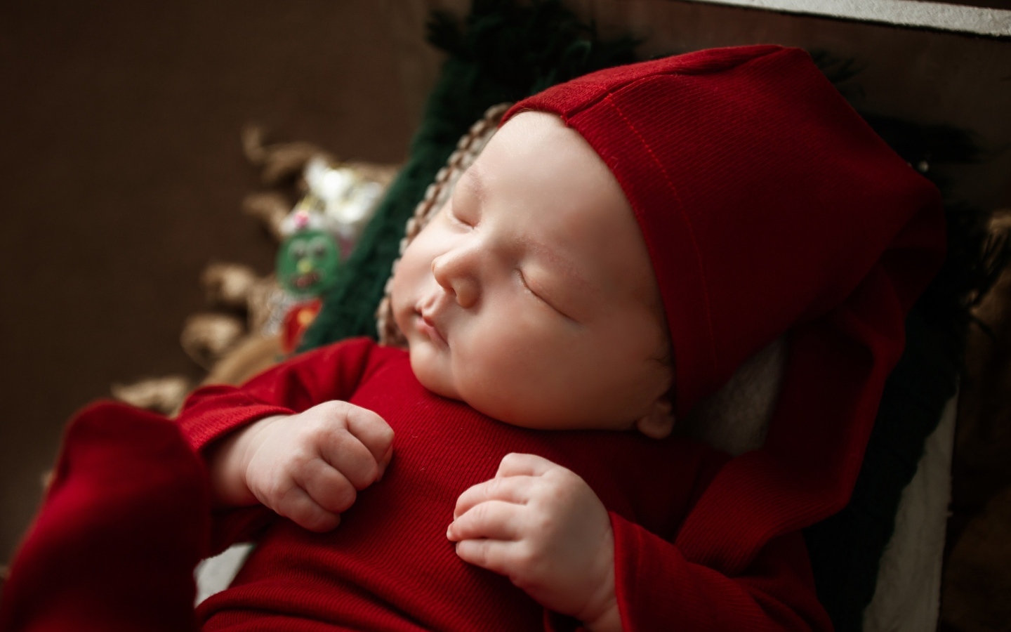 Маленький ребенок спит в красном костюме