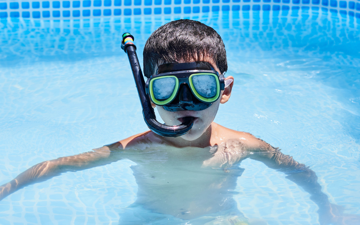 Маленький мальчик в маске в бассейне
