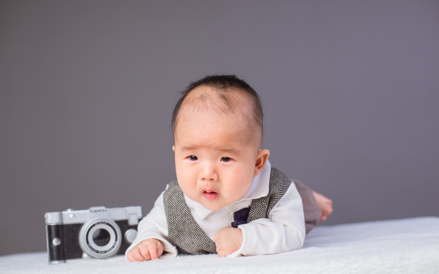 Маленький мальчик в костюме с фотоаппаратом