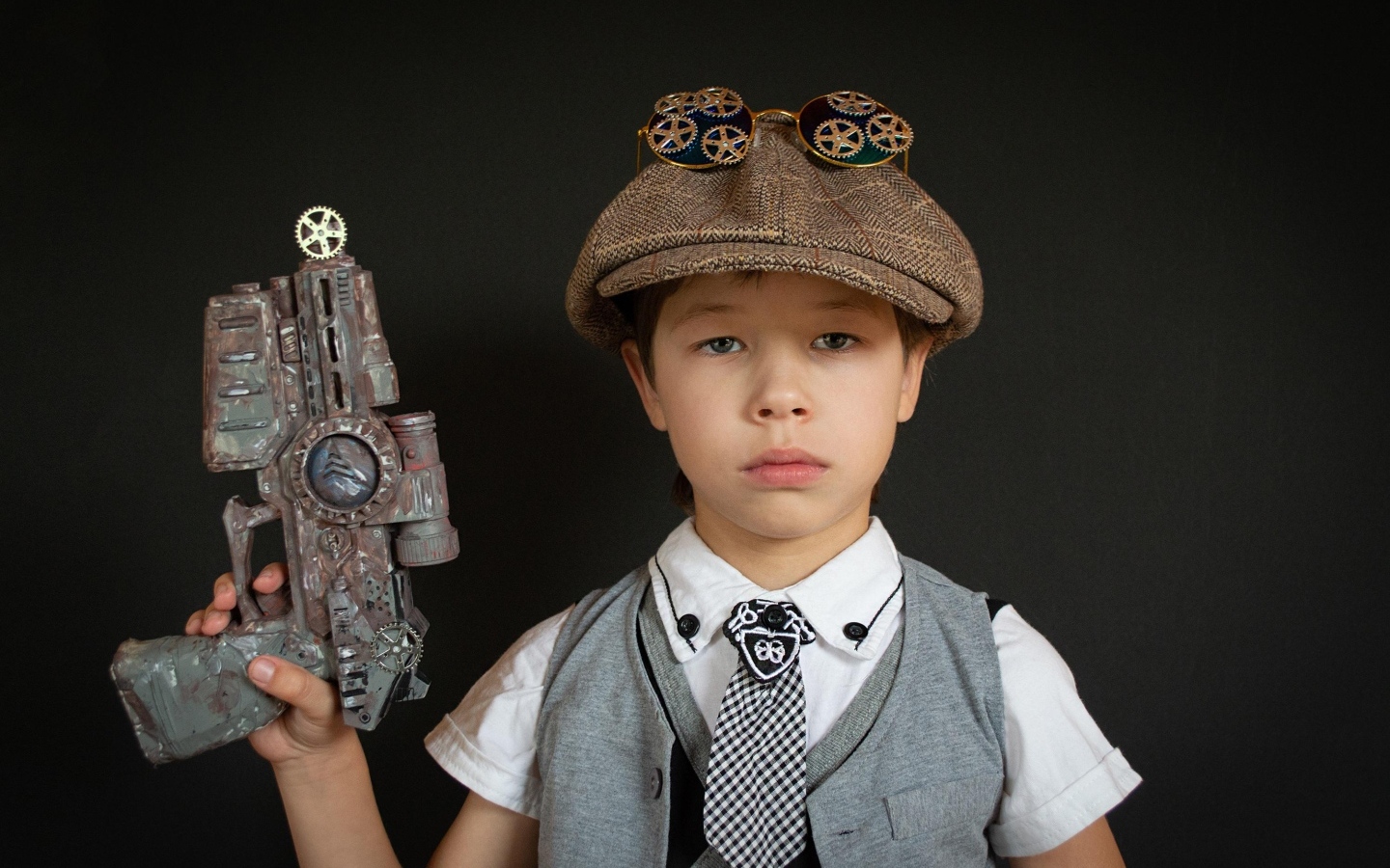 Маленький мальчик с игрушечным пистолетом на черном фоне