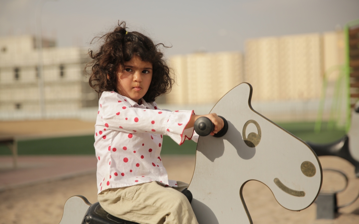 Маленькая девочка на деревянной лошади