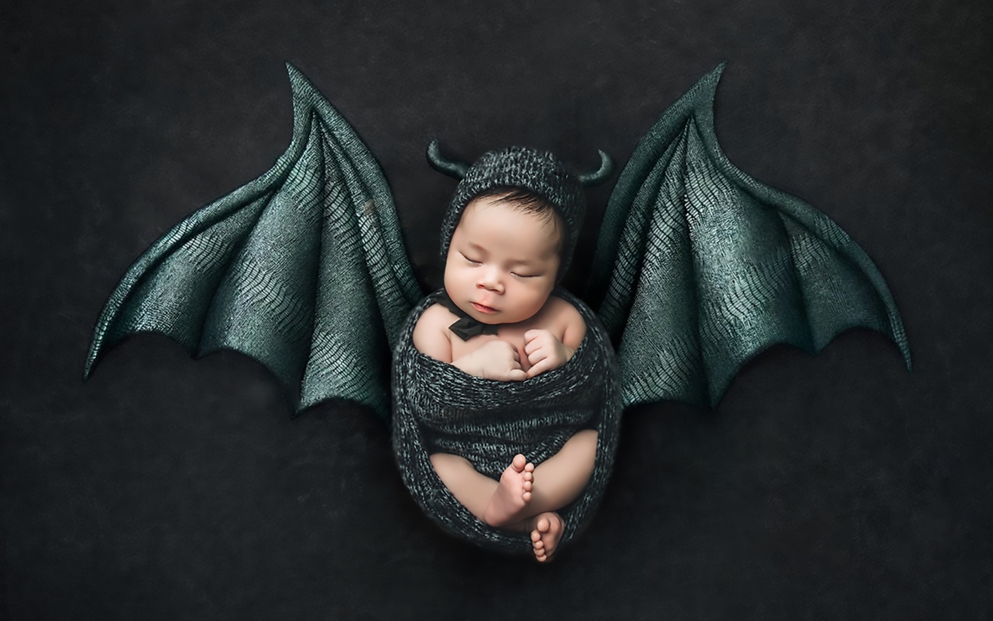 Маленький спящий ребенок с крыльями на Хэллоуин