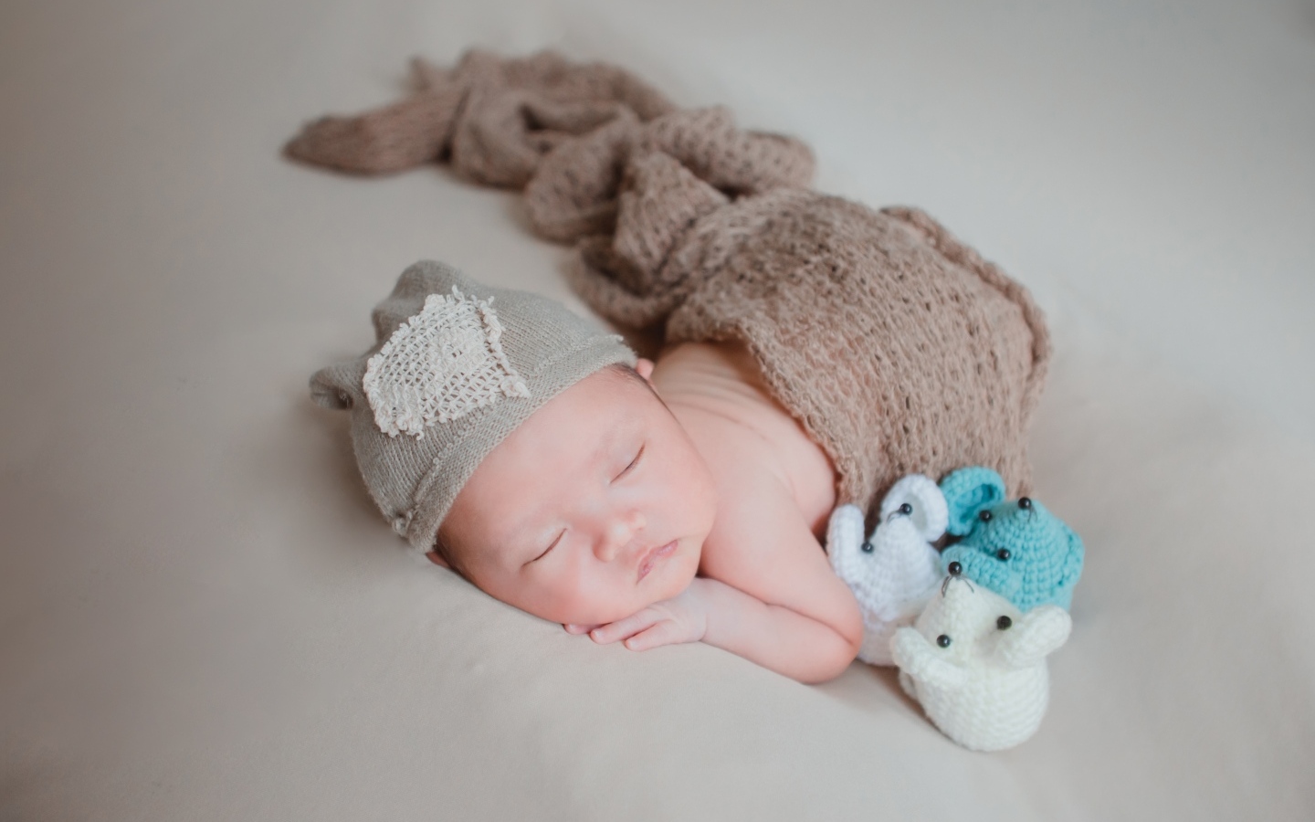 Новорожденный малыш спит на сером покрывале