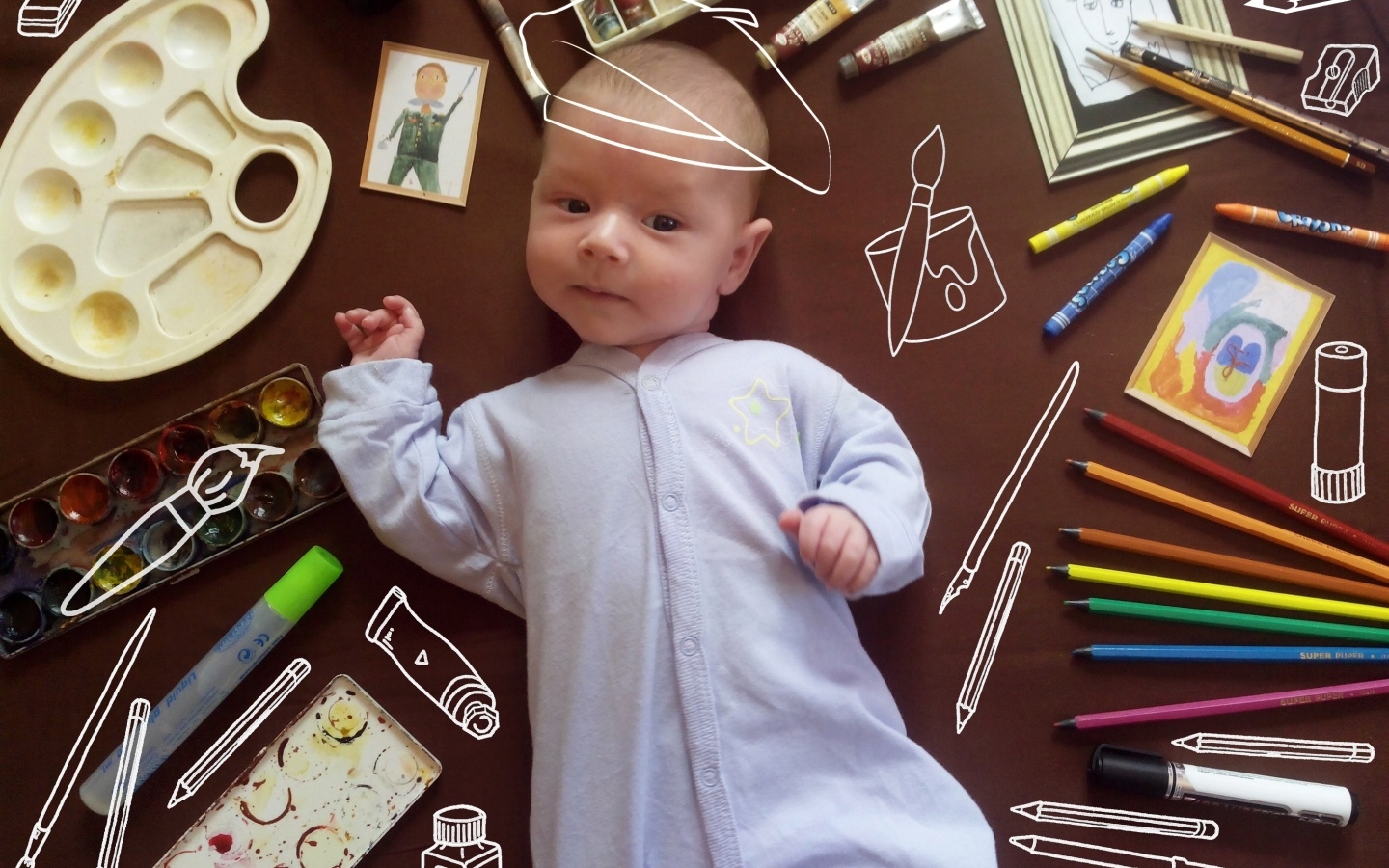 Новорожденный ребенок с канцелярскими предметами