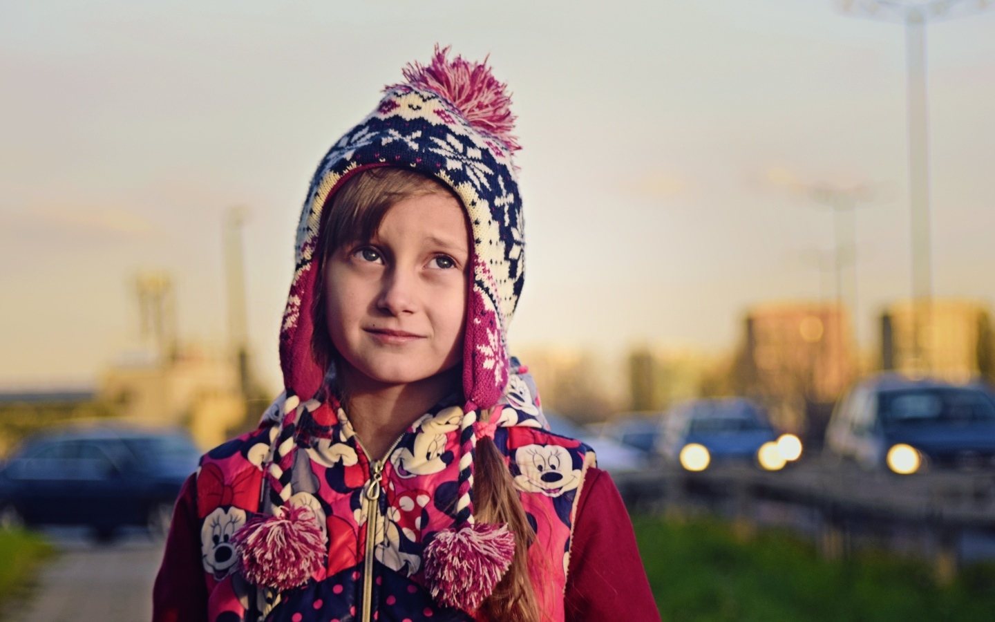 Грустная девочка в теплой шапке на улице