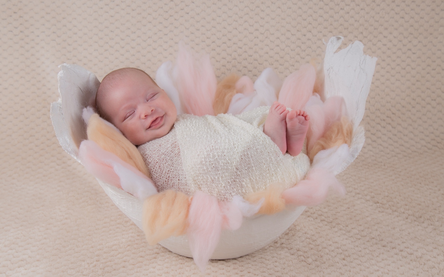 Улыбающийся спящий новорожденный малыш