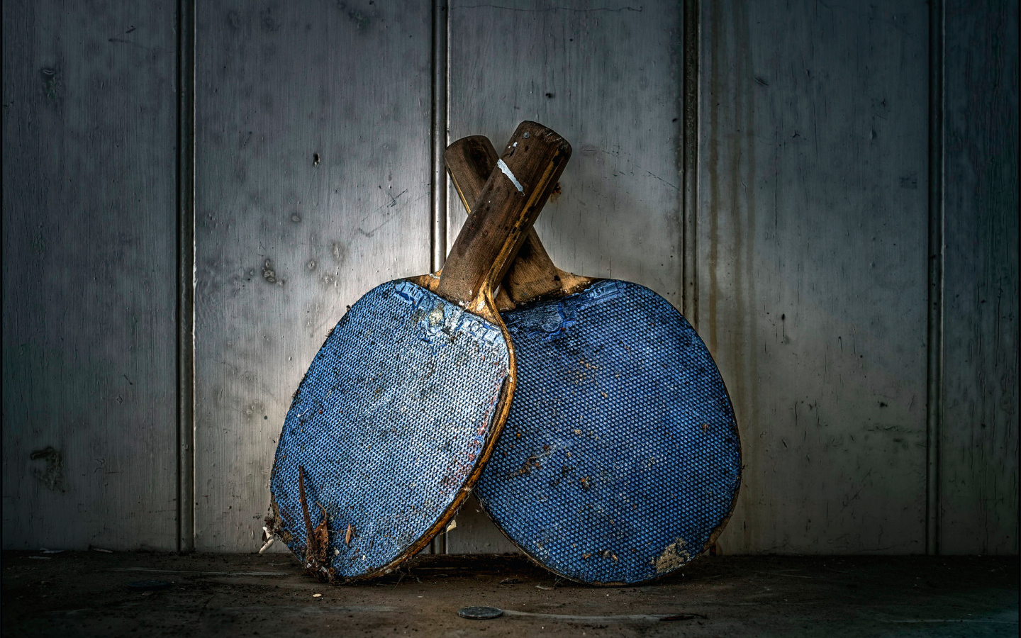 Две старые ракетки для настольного тенниса у стены