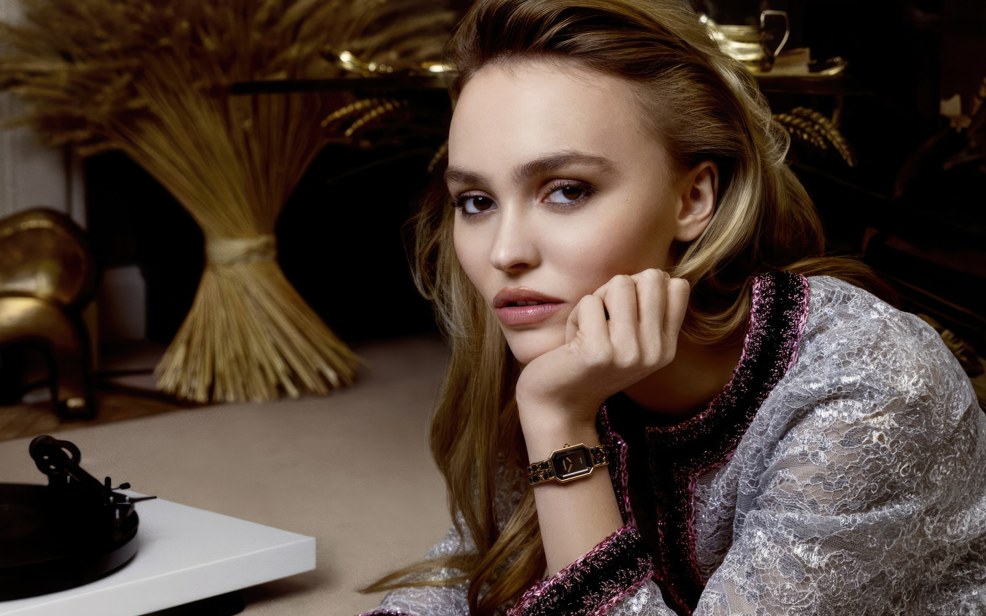 Милая девушка Лили-Роуз Депп сидит за столом