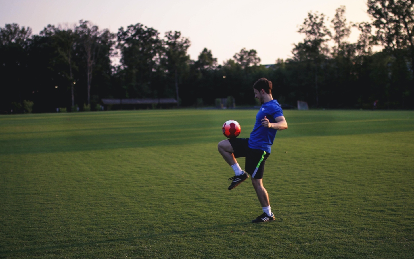 Мужчина футболист с мячом на поле