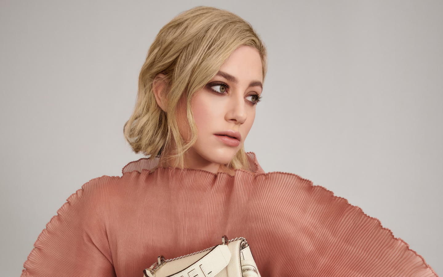 Грустный взгляд актрисы Лили Рейнхарт на сером фоне