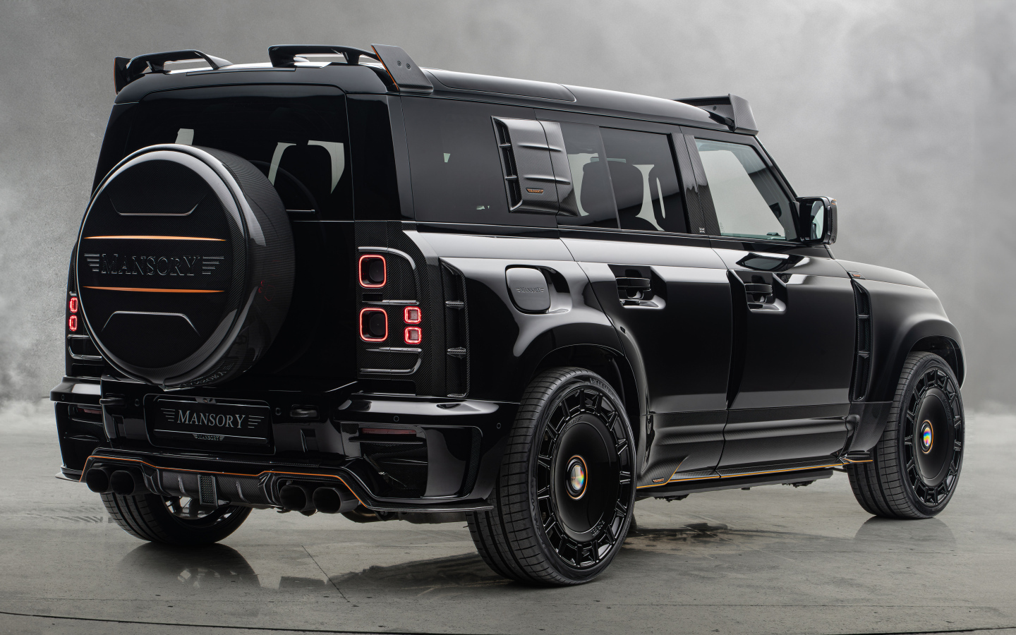 Вид сзади на черный автомобиль Mansory Land Rover Defender 110 Black Edition 2024 года