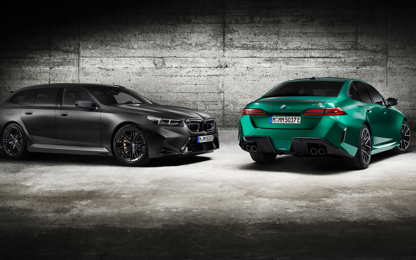 Два автомобиля BMW M5 2024 года на фоне серой стены