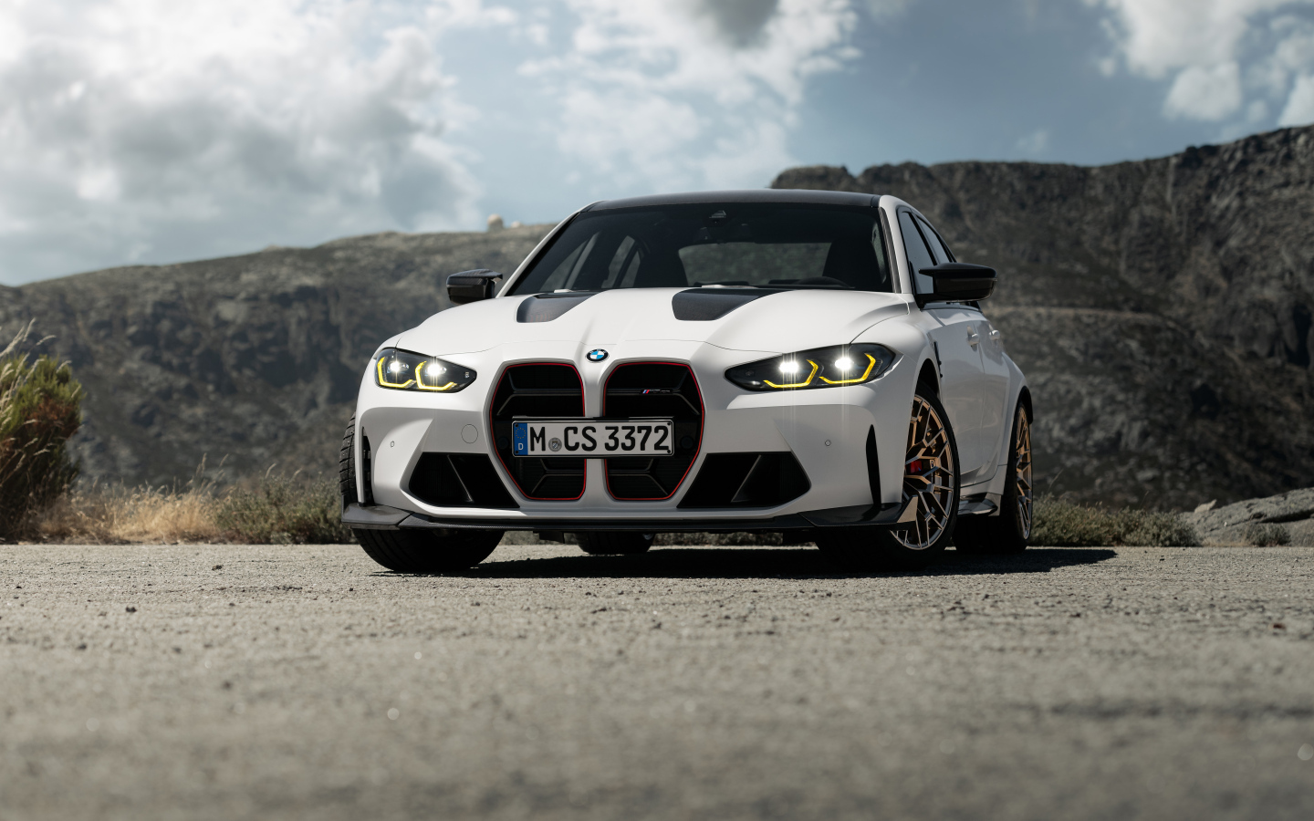 Белый автомобиль BMW M3 CS  на фоне гор