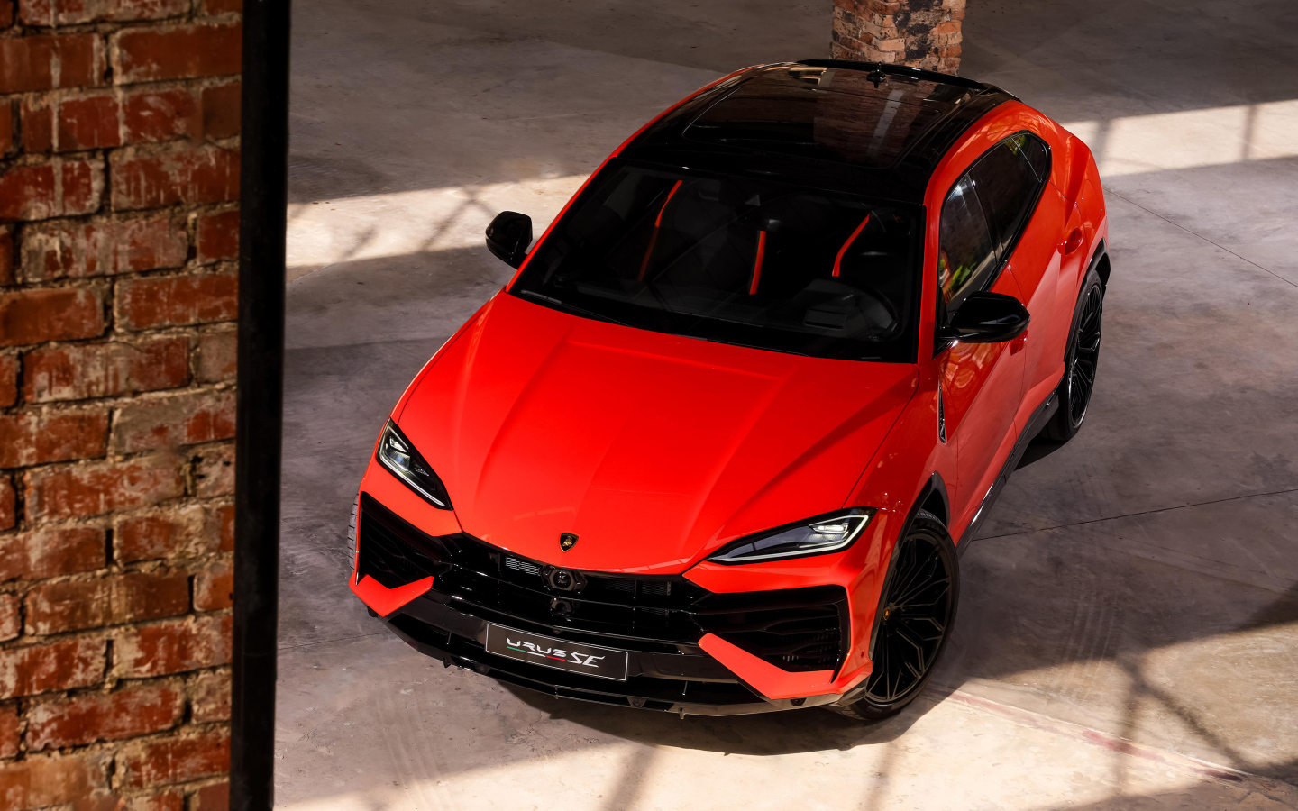 Вид сверху на красный внедорожник Lamborghini Urus SE 2024 года