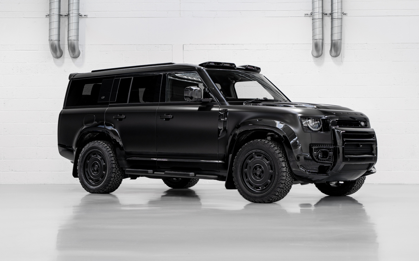 Большой черный автомобиль Land Rover Defender Widetrack 2024 года