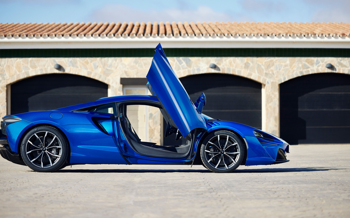 Синий автомобиль McLaren Artura с открытыми дверями