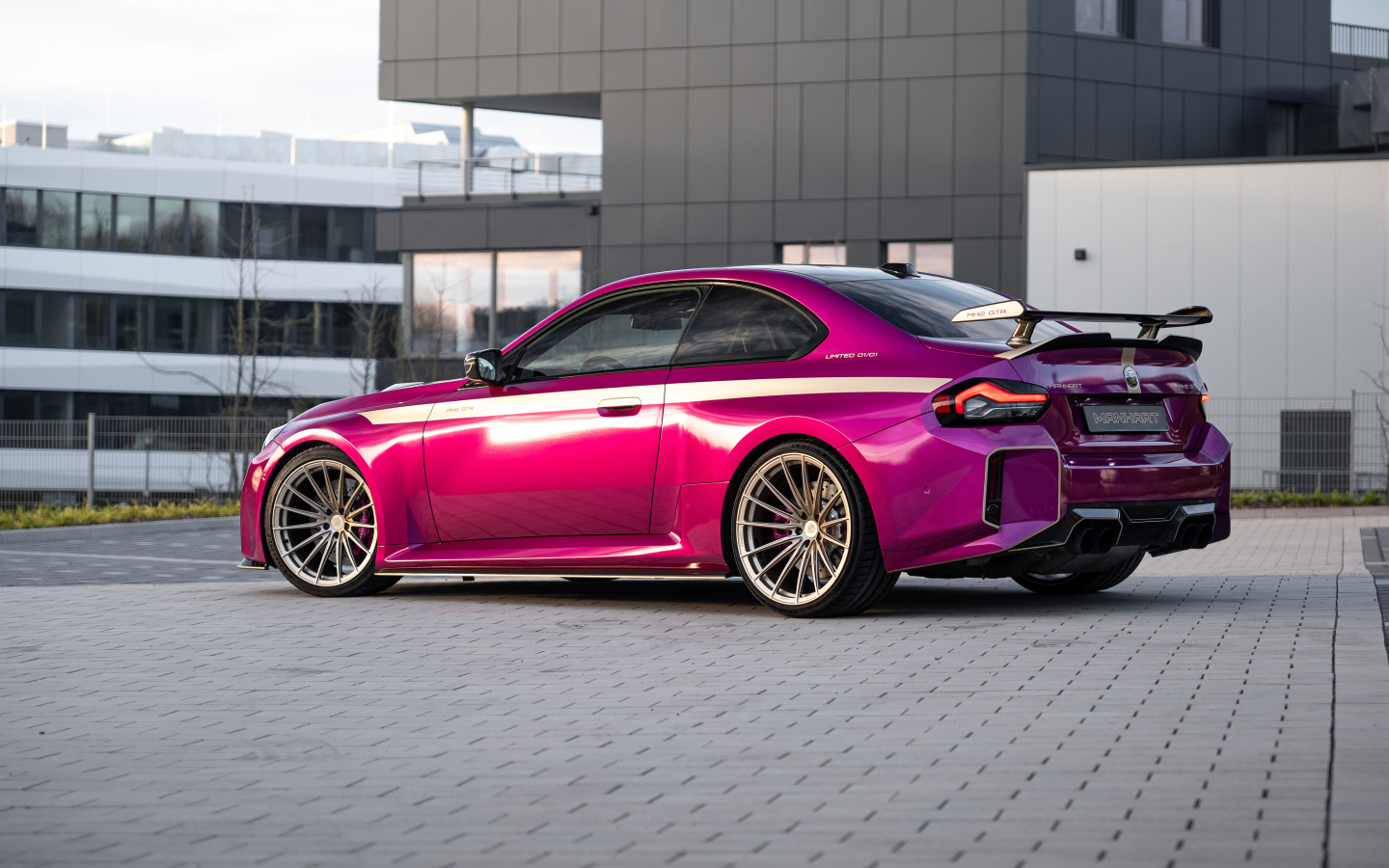 Вид сзади на розовый автомобиль Manhart MH2 GTR II 2024 года