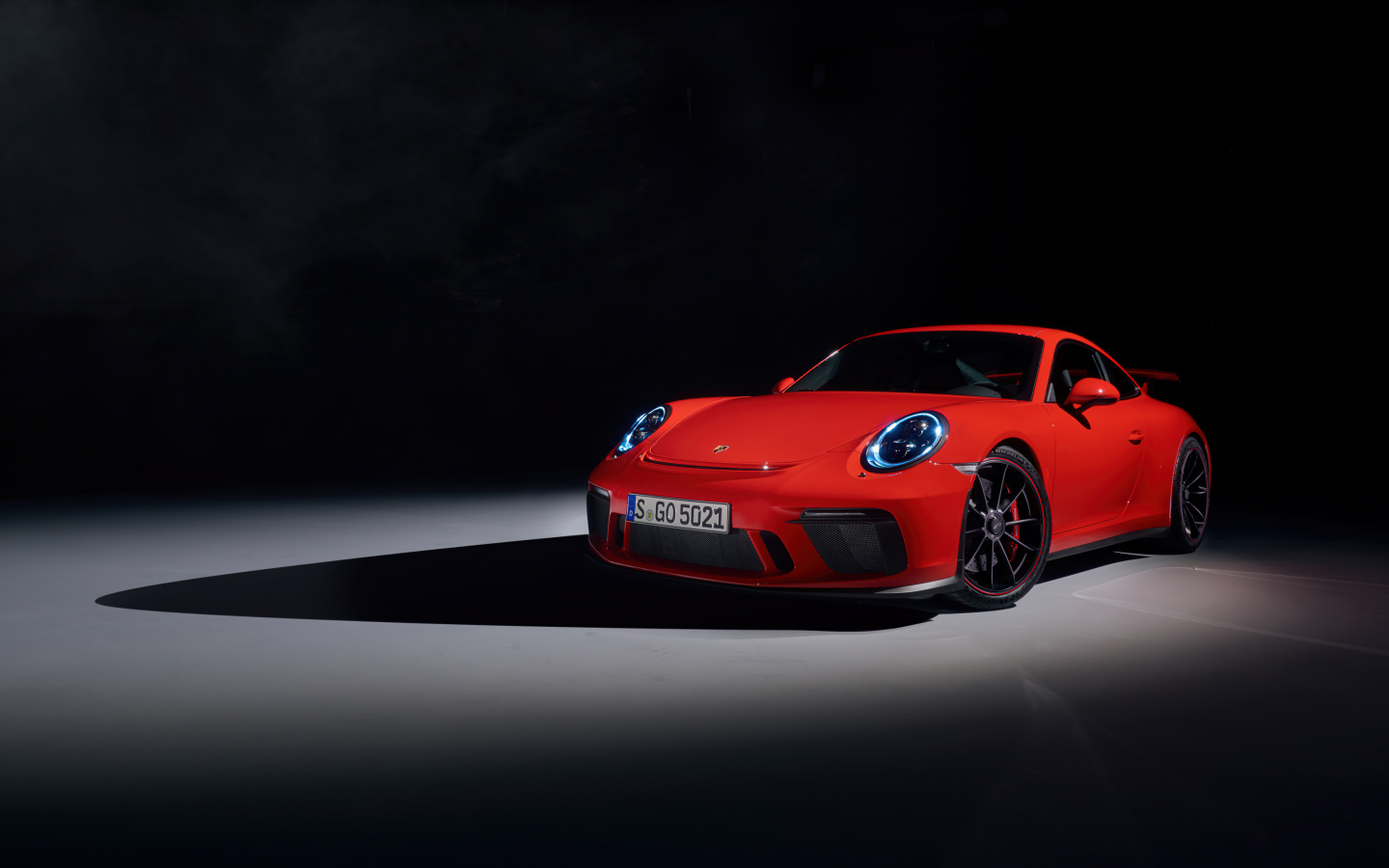 Красный автомобиль Porsche 911 GT3 на черном фоне