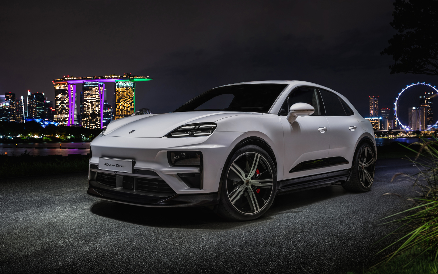 Внедорожник Porsche Macan Turbo 2024 года на фоне ночного города